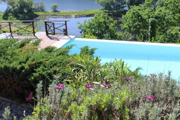 Casa antiga de pedra com piscina e vista rio